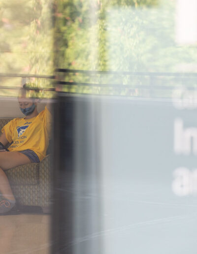 Masked Penn State IST student through window.